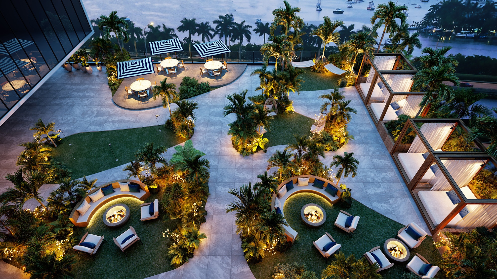 Jardines exteriores de Shoma Bay con fogatas, áreas de descanso y vistas al agua al anochecer.